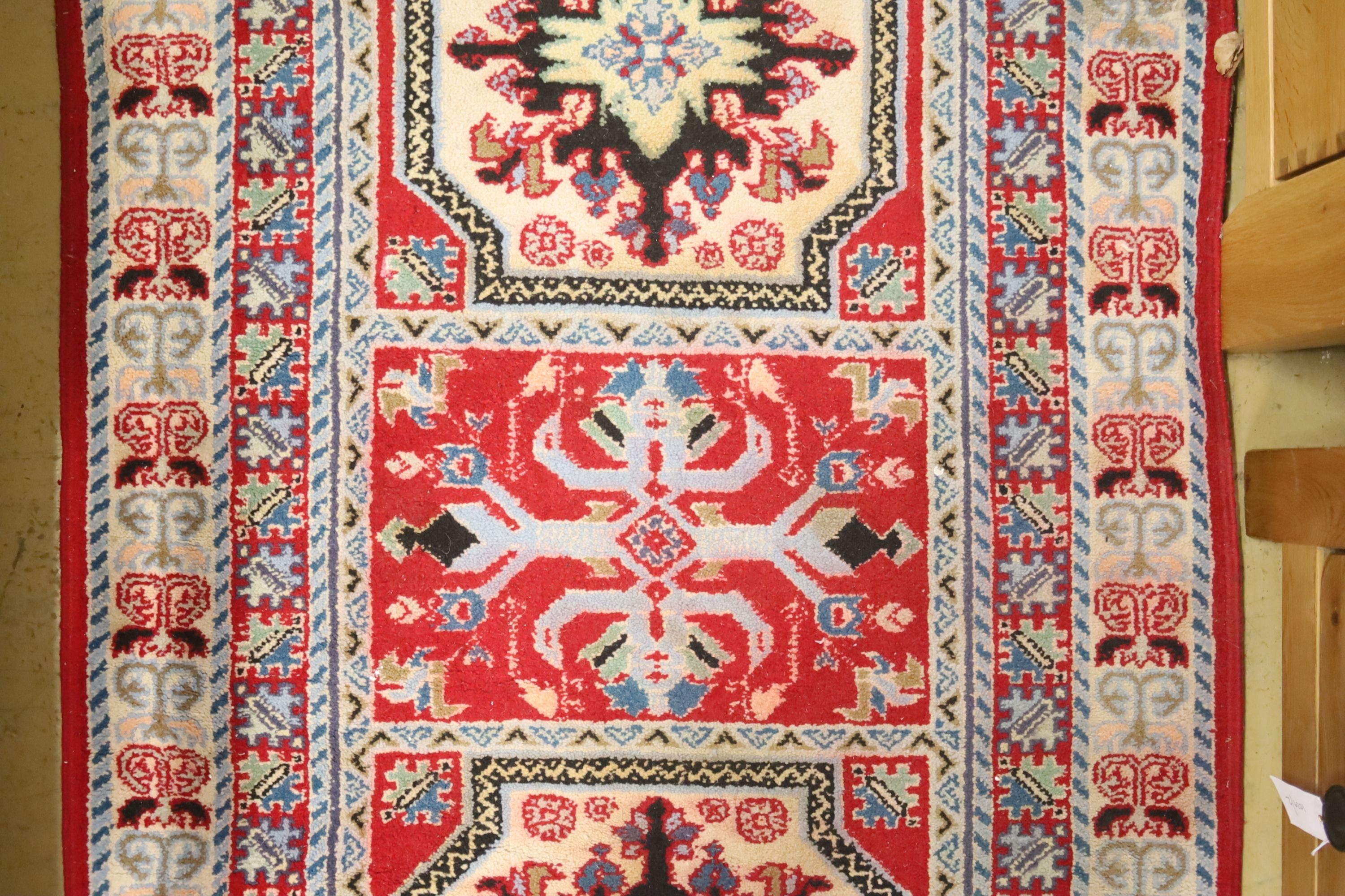 A Kazak style ivory ground rug, 144 x 64cm